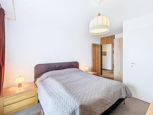 a bedroom with a bed and a pendant light at Apartment Allod Park Haus C 505 by Interhome in Davos