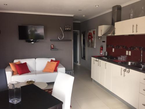 a living room with a white couch and a kitchen at Malika Apartments in Westpunt