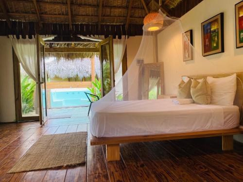 a bedroom with a bed and a large window at Palmeras del valle in La Majagua