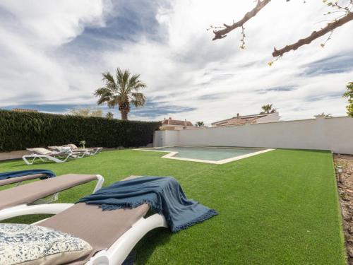 a backyard with a lawn with chairs and a table at Holiday Home Stefania by Interhome in Riumar