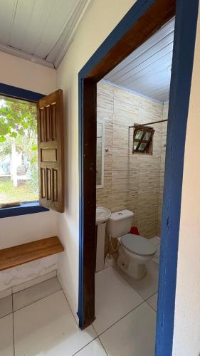 a bathroom with a toilet and a window at Calango Hostel in Ibicoara