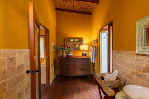 a bathroom with yellow walls and a sink and a mirror at Gocta Natura Reserve in Cocachimba