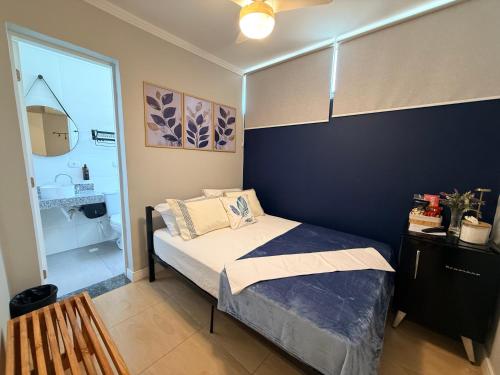 a bedroom with a bed and a blue wall at Villa Catarina in Guarulhos