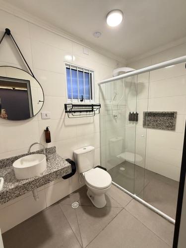 a bathroom with a toilet and a sink and a shower at Villa Catarina in Guarulhos