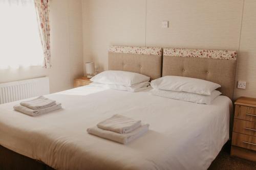 a bedroom with a white bed with towels on it at Upper Cliff 4 in Easton