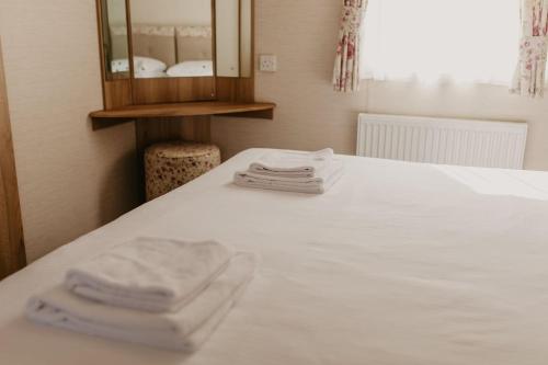 two towels sitting on top of a white bed at Upper Cliff 4 in Easton
