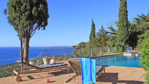 a house with a swimming pool and a chair at Villa Lucienne in Les Issambres