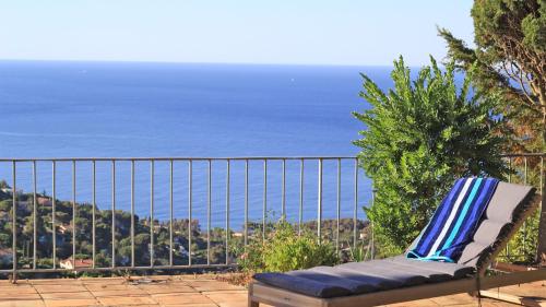 a chair sitting on a balcony overlooking the ocean at Villa Lucienne in Les Issambres