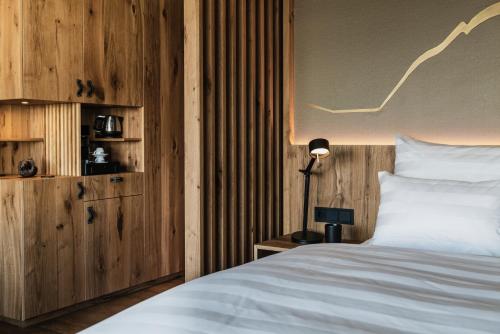 a bedroom with a bed and a desk with a lamp at Berghotel Kleiner Biber in Warth am Arlberg