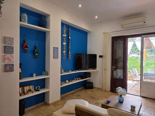 a living room with blue walls and a tv at Bedda Mia - Lipari in Lipari