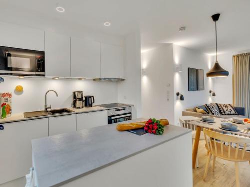a kitchen with white cabinets and a counter top at Apartment Seezauber by Interhome in Lembruch