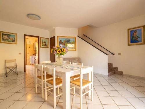 a white dining room with a white table and chairs at Apartment Rais 13 by Interhome in Stintino