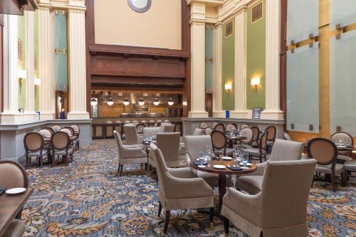 a restaurant with tables and chairs and a bar at The Battle House Renaissance Mobile Hotel & Spa in Mobile