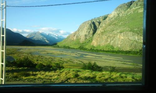 a view of a river and mountains from a window at La Ribera - Sepúlveda 191 in El Chalten
