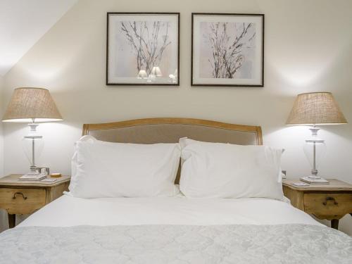 a bedroom with a white bed with two lamps at 2 Bed in Chipping Campden oc-78128 in Chipping Campden