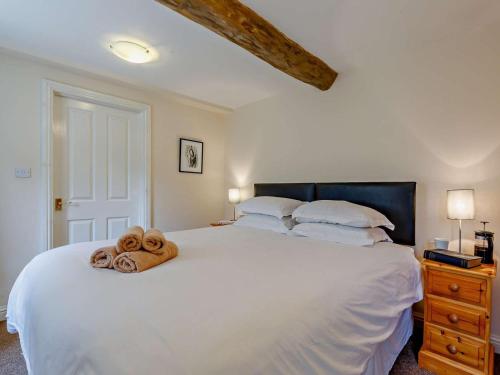 a bedroom with a large white bed with towels on it at 3 Bed in Eyam oc-pk835 in Eyam
