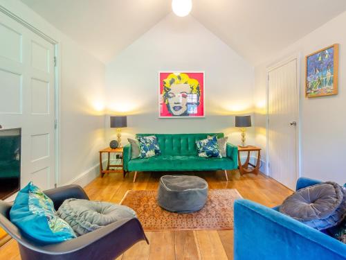 a living room with a green couch and chairs at Forest View Barn in Balcombe