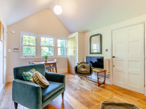 a living room with a blue chair and a table at Forest View Barn in Balcombe