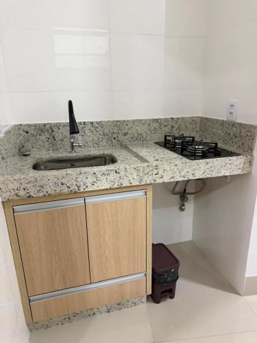 a kitchen counter with a sink and a stove at Hotel Marinho in Gurupi