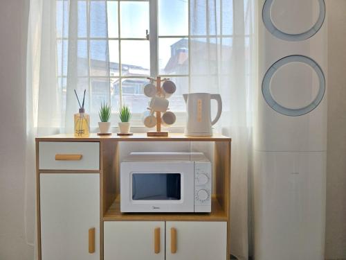 a kitchen with a microwave on a counter with a window at 수원 행궁 Haru Stay in Suwon