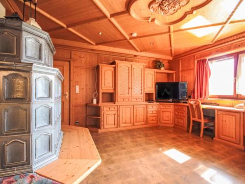 a large kitchen with wooden cabinets and a tv at Chalet Schlitters by Interhome in Schlitters