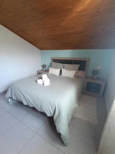 a bedroom with a large bed with a wooden ceiling at Casa María 3 in Barcia