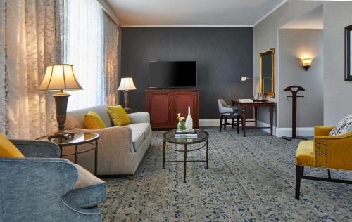 a living room with a couch and a tv at The Battle House Renaissance Mobile Hotel & Spa in Mobile