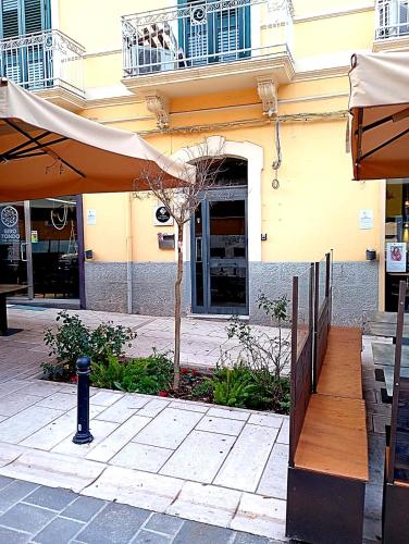 a patio with an umbrella and a tree in front of a building at Le Gemme Rooms in Matera