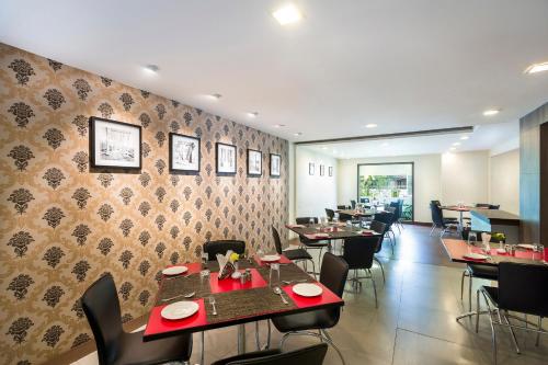 a restaurant with tables and chairs in a room at The Lotus Apartment Hotel, Venkatraman Street in Chennai