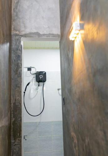 a bathroom with a shower with a camera on the wall at City Villa Dikwella in Dickwella