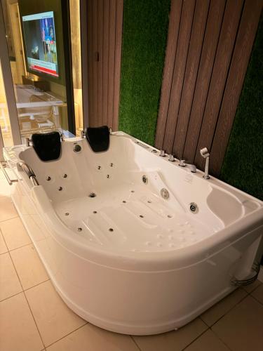 a large white bath tub in a room with a tv at برج داماك الجوهرة جدة - Damac Al Jawharah Tower in Jeddah