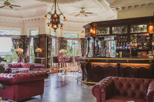 a bar with a couch and chairs in a room at Merewood Country House Hotel in Windermere
