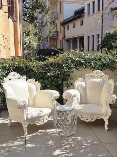 a group of white chairs sitting on a patio at LEONI DI COLLALTO PALACE in Treviso