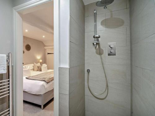 a bathroom with a shower and a bed in a room at 4 Bed in Middleham oc-g0189 in Middleham