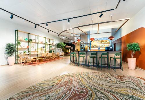 a lobby with a bar and tables and chairs at B&B HOTEL Geneva Airport in Geneva