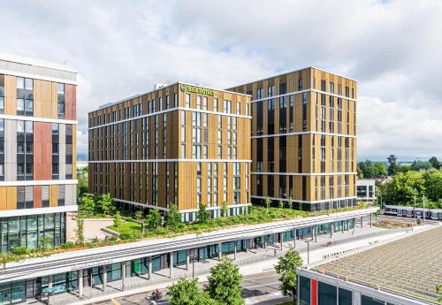 a rendering of three tall buildings next to a street at B&B HOTEL Geneva Airport in Geneva