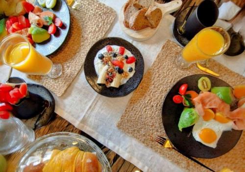 a table with plates of food and glasses of orange juice at Casa by Anita Guesthouse in Esposende