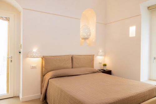 a bedroom with a bed with two lights above it at Aria di Mare CENTER HOME in Vieste