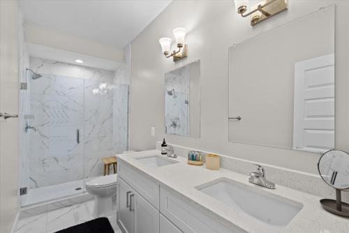 a white bathroom with a sink and a toilet at Entire DC House 3BR 3BA RoofDeck Free Parking Near Capitol Hill in Washington, D.C.