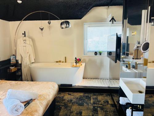 a large bathroom with a tub and a sink at Bed & Breakfast Maison Noire Westende-bad incl parking & ontbijt in Middelkerke