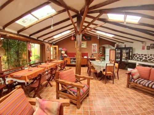 una sala da pranzo con tavoli, sedie e finestre di EColodge Ccatan a Urubamba