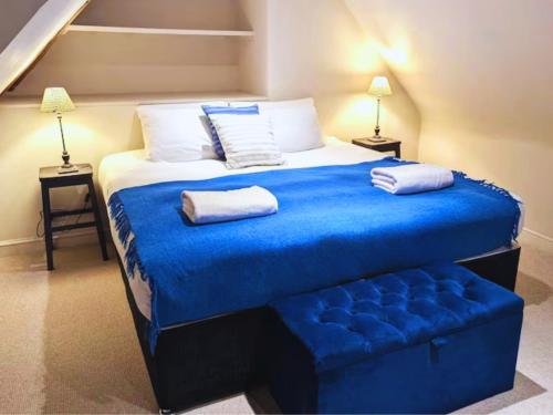a bedroom with a large bed with blue sheets and pillows at West Pallant Georgian Townhouse in City Centre with Courtyards, BBQ & Log Burners - Dogs Welcome! Chichester Holiday Properties in Chichester
