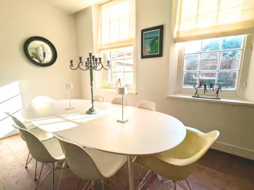 a dining room with a white table and chairs at West Pallant Georgian Townhouse in City Centre with Courtyards, BBQ & Log Burners - Dogs Welcome! Chichester Holiday Properties in Chichester
