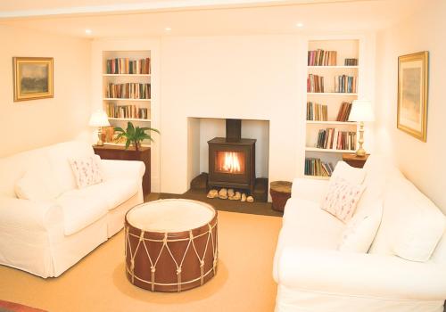 a living room with two white couches and a fireplace at West Pallant Georgian Townhouse in City Centre with Courtyards, BBQ & Log Burners - Dogs Welcome! Chichester Holiday Properties in Chichester