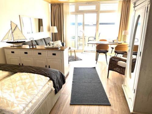 a bedroom with a bed and a desk and a table at Strandliebe-I-mit-Balkon in Burgtiefe auf Fehmarn 