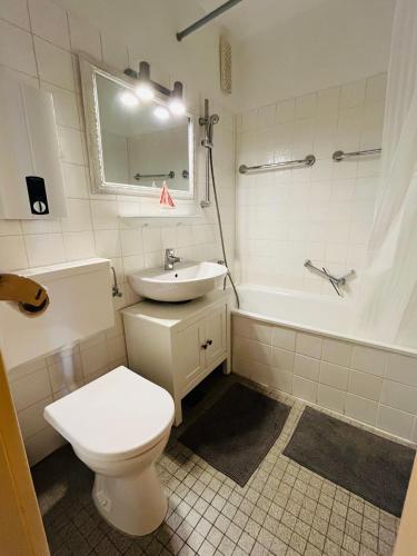 a bathroom with a toilet and a sink and a tub at Strandliebe-I-mit-Balkon in Burgtiefe auf Fehmarn 