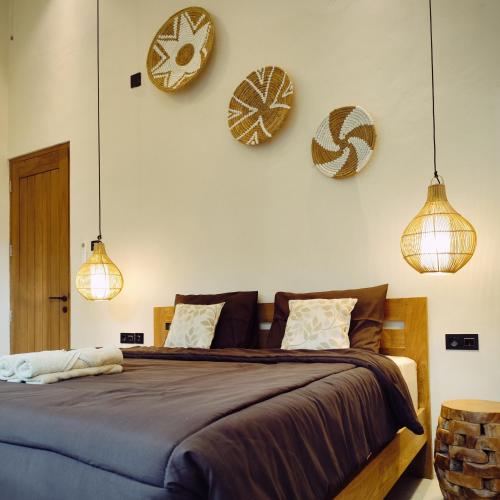 a bedroom with two clocks on the wall and a bed at Casa Benna - Salatiga in Salatiga