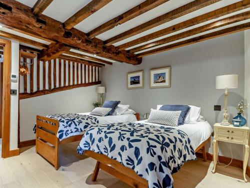 two beds in a room with wooden ceilings at 2 Bed in Broadway oc-62262 in Broadway
