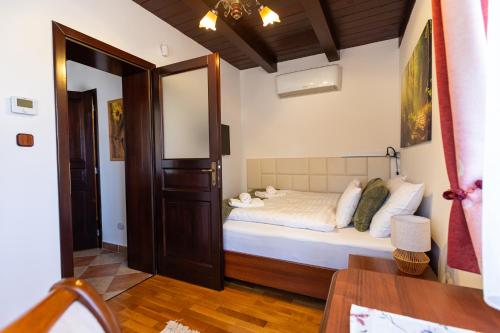 a small bedroom with a bed and a table at Bakonyi Múzsa Vendégház in Bakonyszentlászló