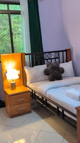 a teddy bear laying on two beds in a room at Zion Crest Suites - Kilimanjaro Helichrysum Homes in Arusha